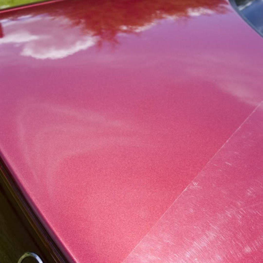 Close-up of a red car's hood polished with Bilt Hamber Cleanser-Polish. before and after