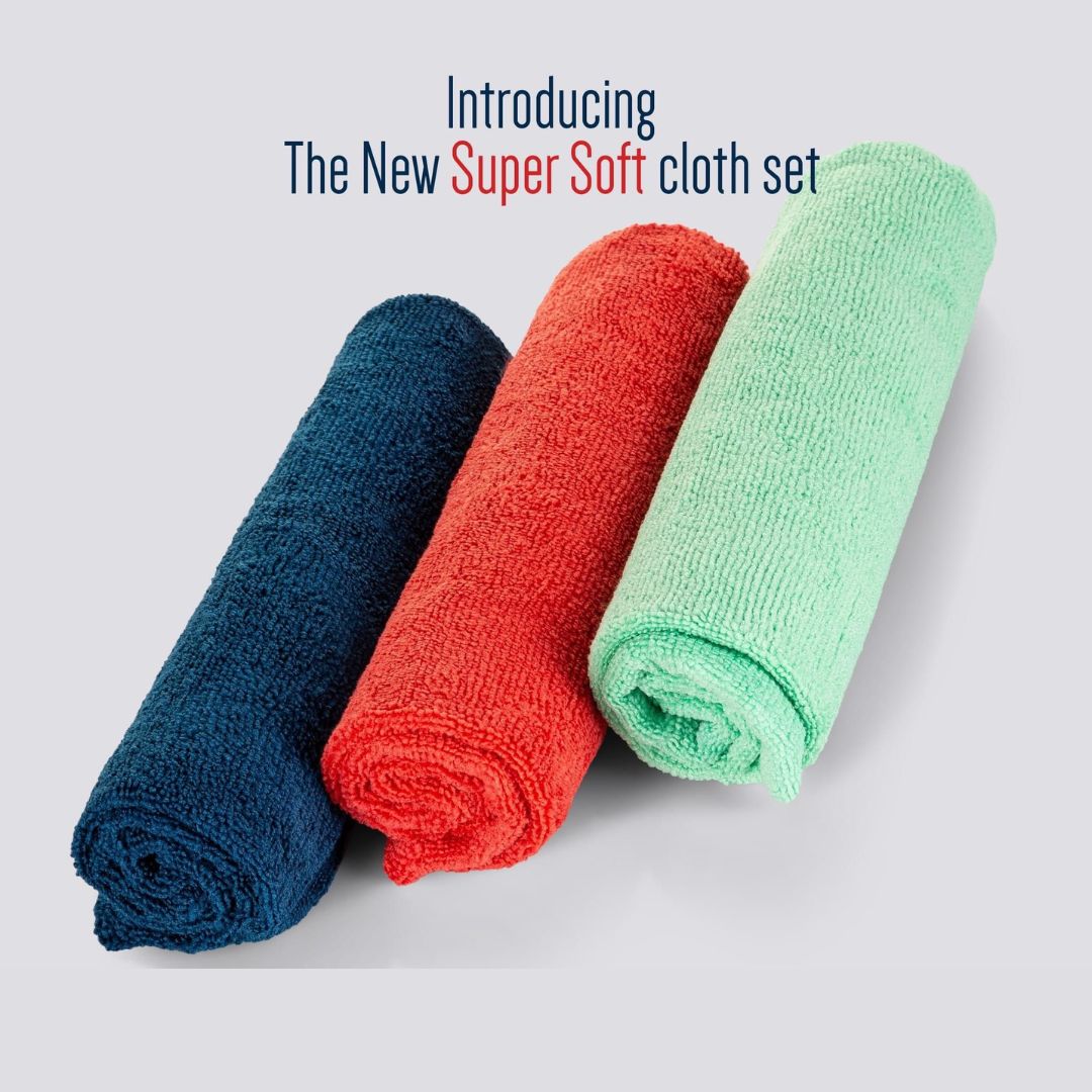 Three rolled-up cloths in blue, red, and green on a light gray background with text 'Introducing The New Super Soft cloth set'.