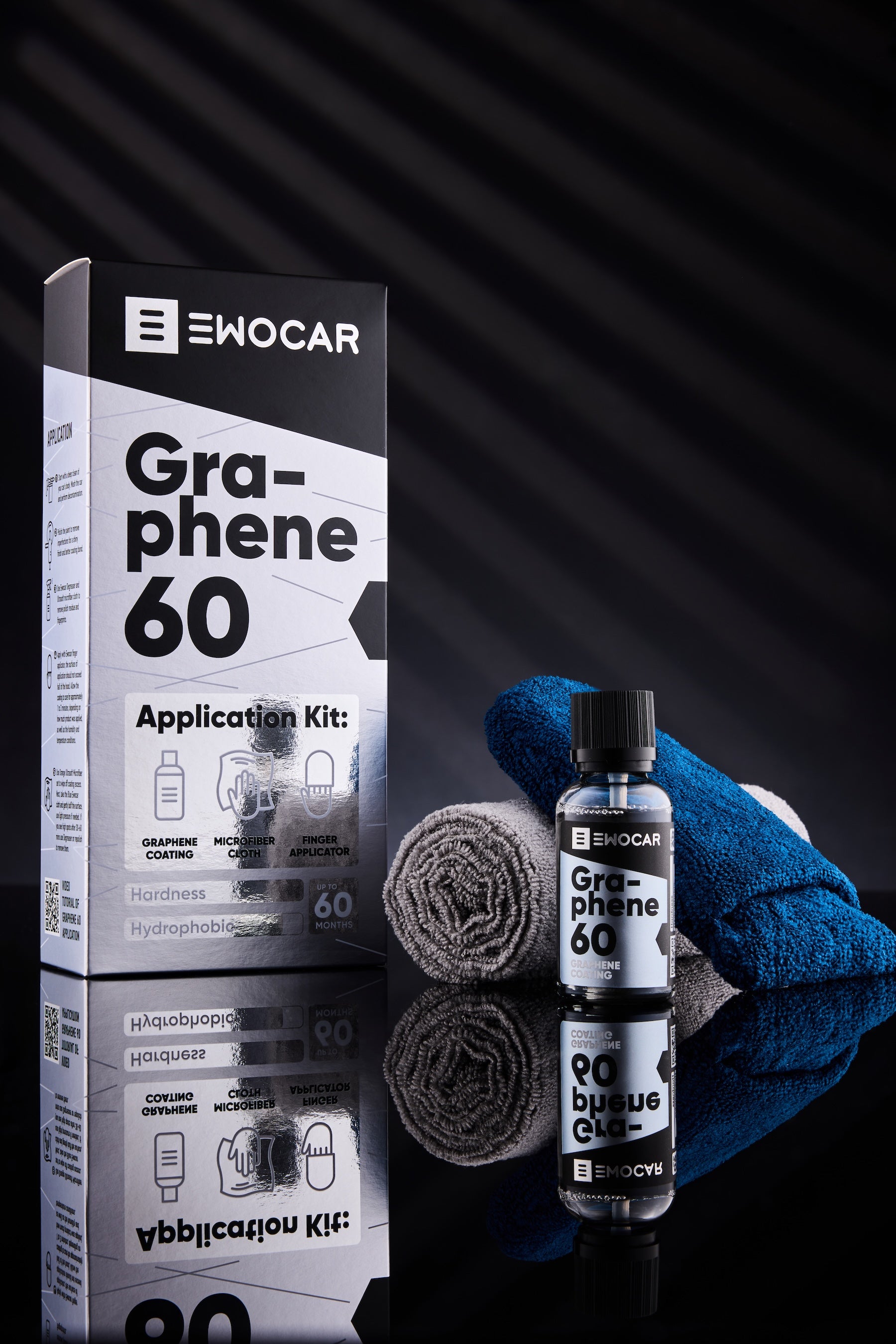 EWOCAR Graphene 60 application kit with packaging, bottle, towel, and cloth on a reflective surface.