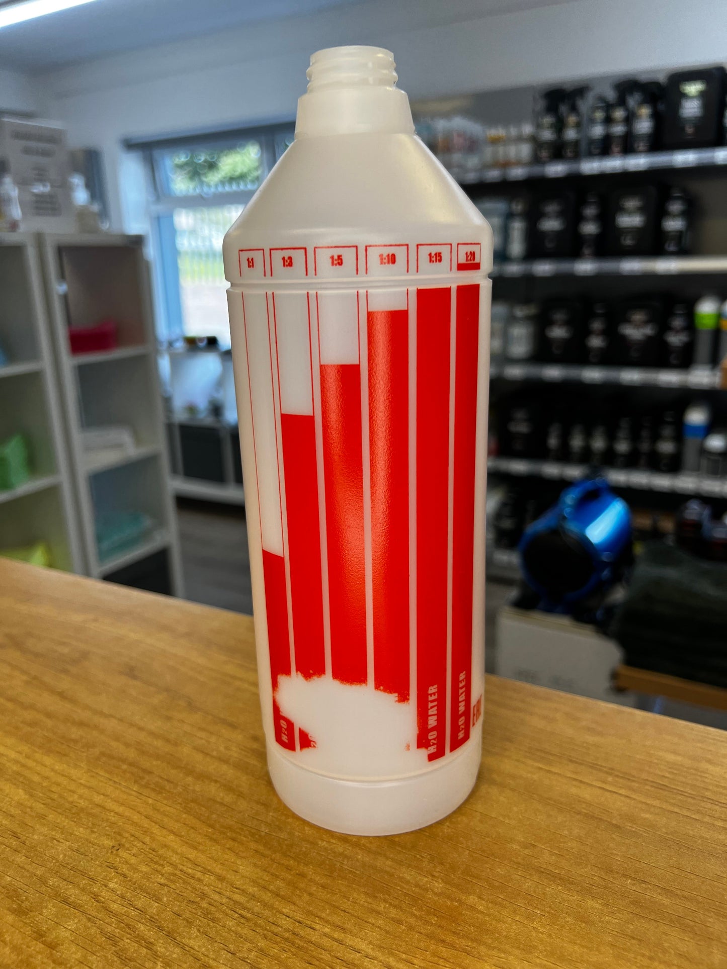 White bottle with red labels on a wooden surface