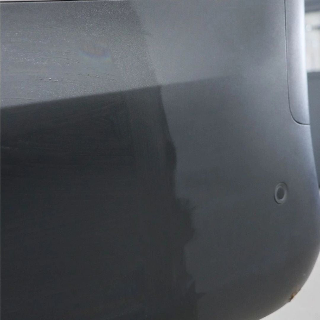 Close-up of a dark gray surface with a small circular object on it. 50:50 Koch Chemie HPC Hydro Plast Care