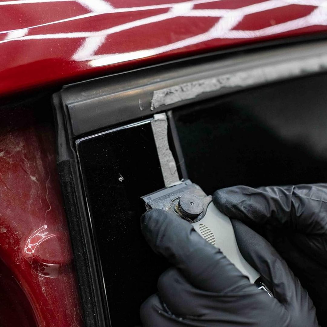 Person using a plastic scrape tool to remove glue residue.