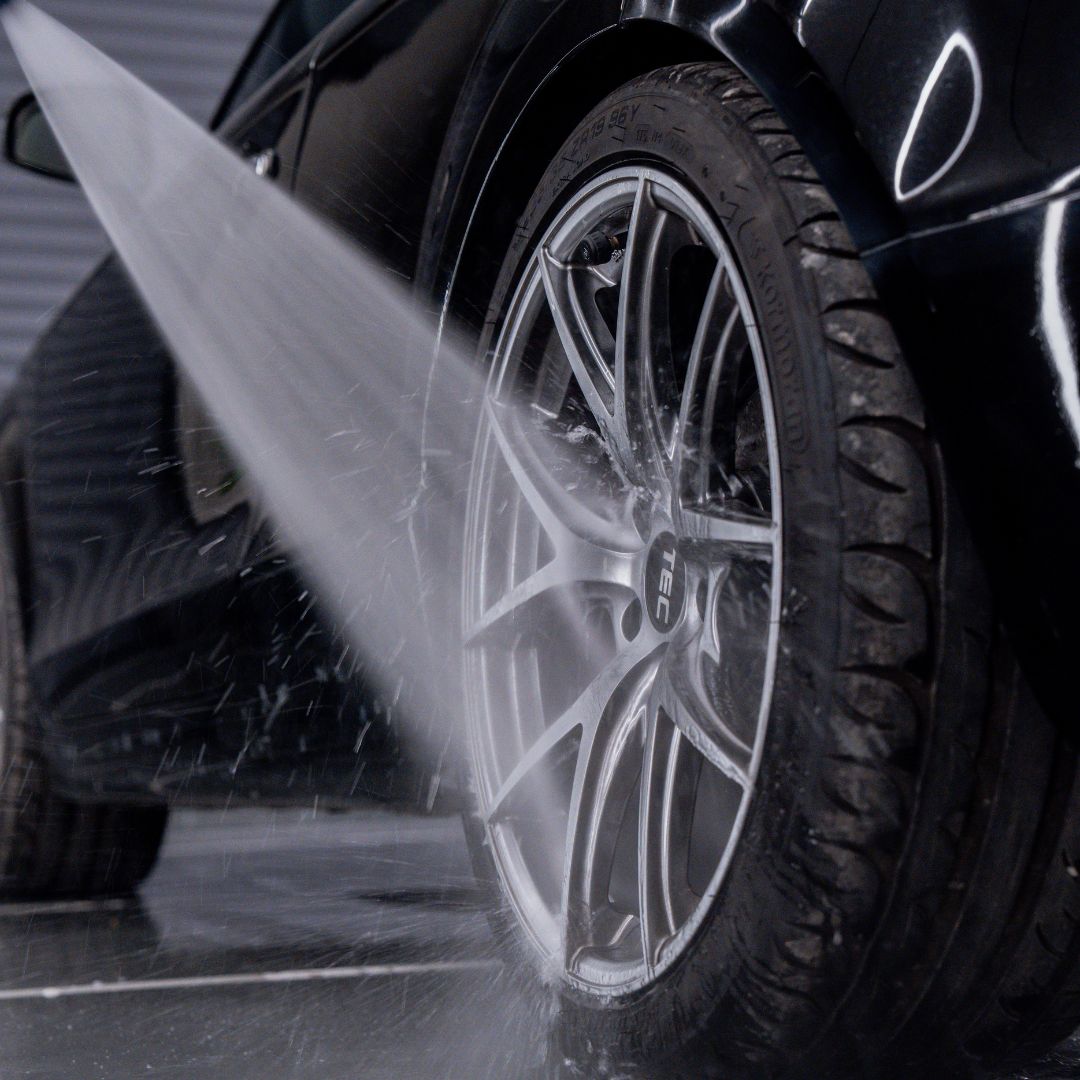 Car tire being washed with a high-pressure water hose