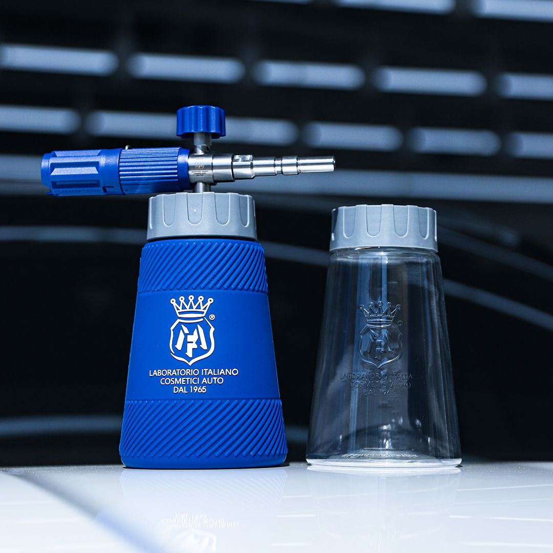 A blue and silver foam cannon attachment with a clear plastic cup, both branded with the Labocosmetica crest, displayed on a reflective white surface against a dark, blurred background.