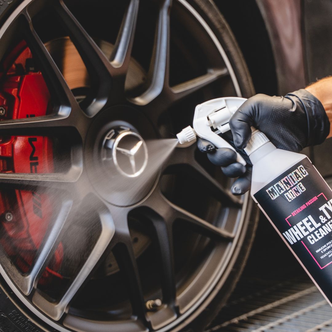Person cleaning a Mercedes AMG wheel with a spray bottle labeled 'Maniac Wheel & Tyre Cleaner'.