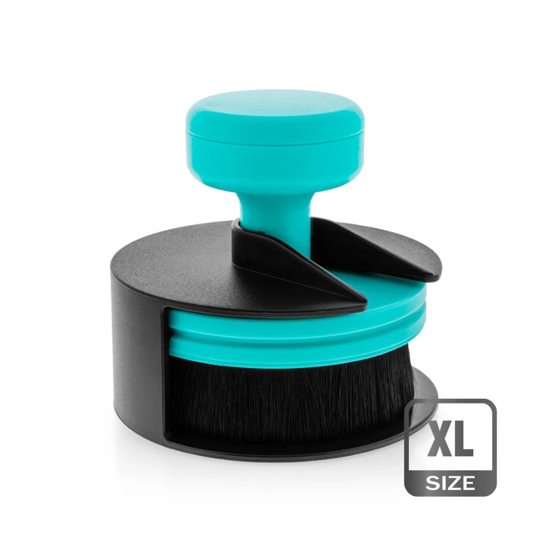 A circular tyre dressing make up brush with a turquoise and black plastic handle and bristles, shown on a white background with an 'XL SIZE' label overlay in the bottom right corner.
