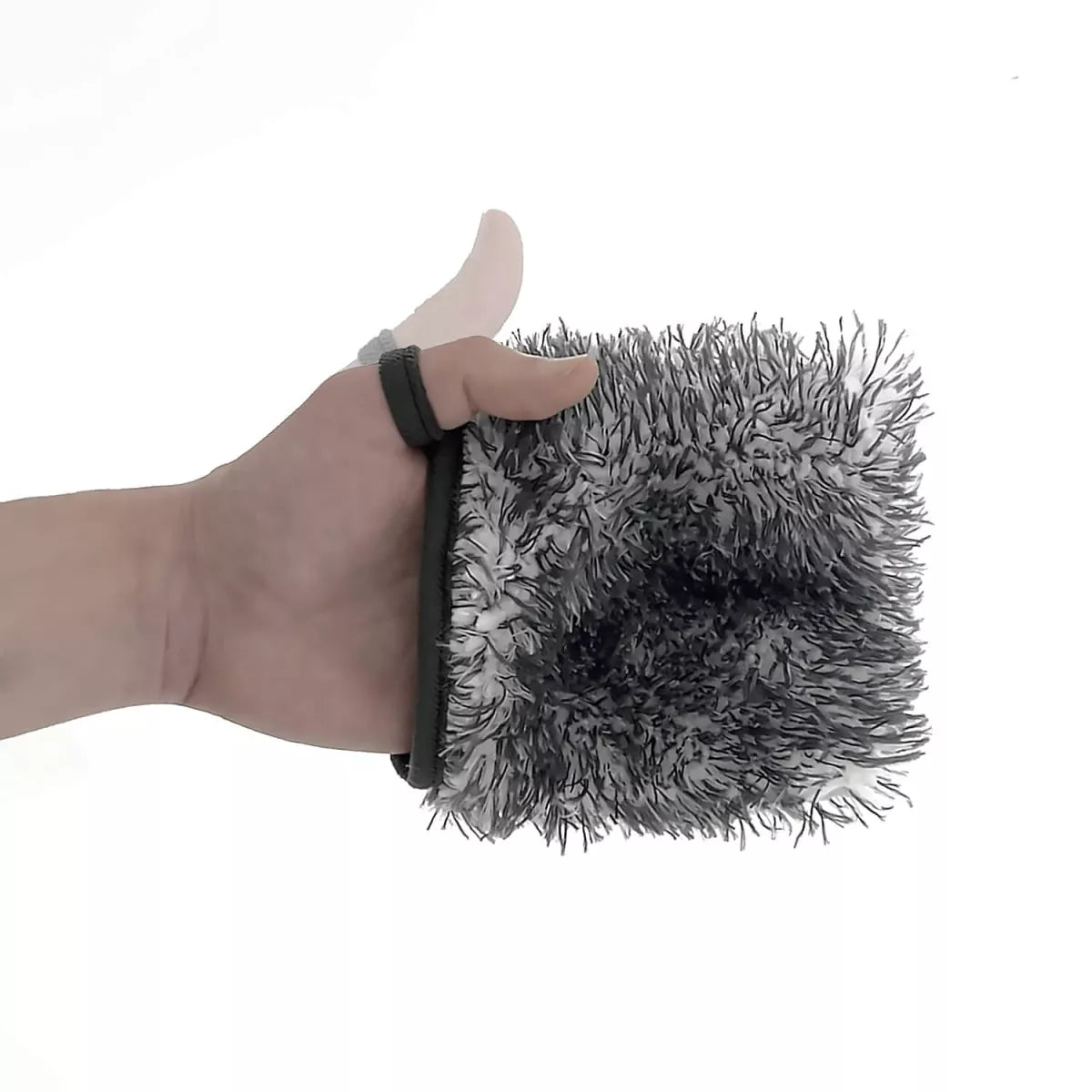 Hand holding a grey chemicalworks wheel mitt object against a white background