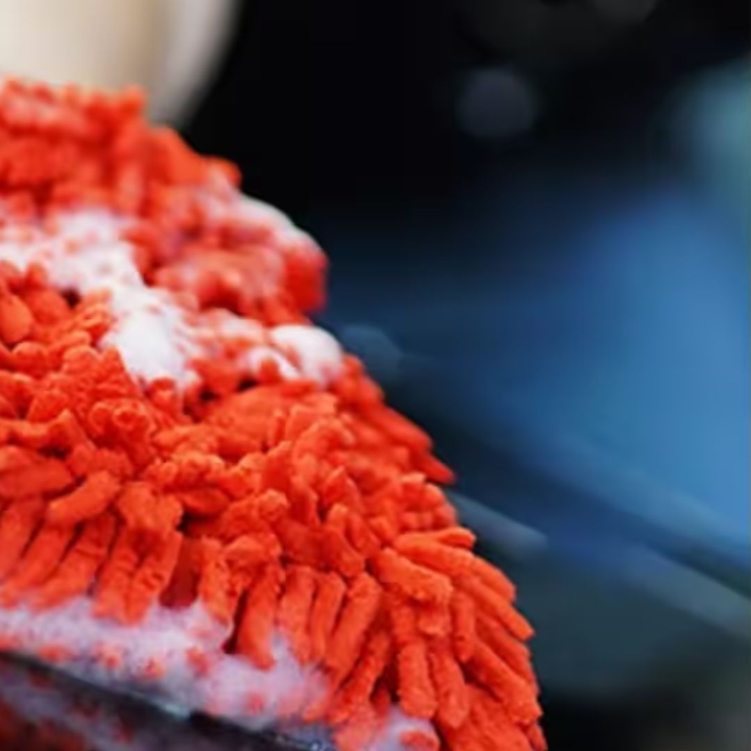 Close-up of an orange microfiber cleaning cloth with a blurred background