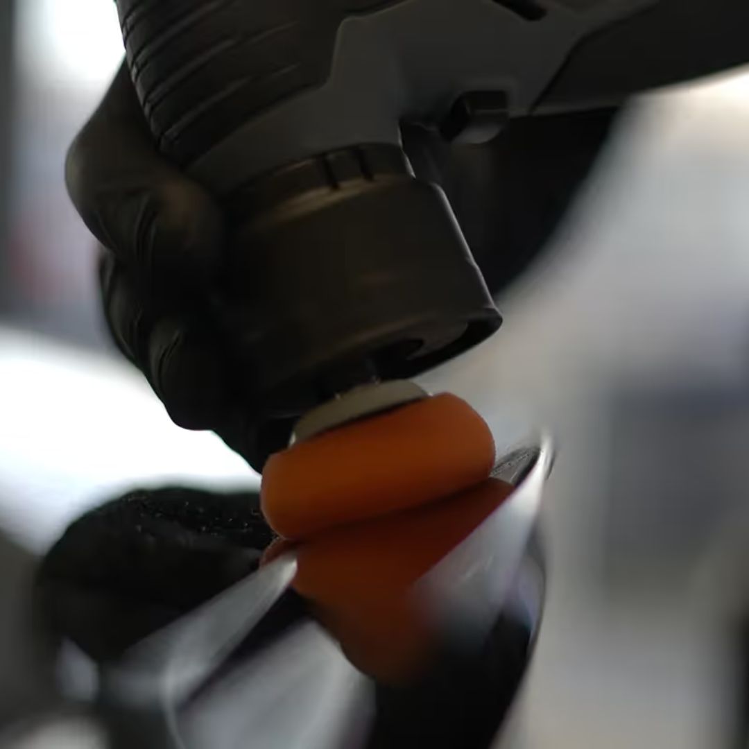 Close-up of a hand wearing a black glove holding an chemicalworkz EVO Mini against a blurred background