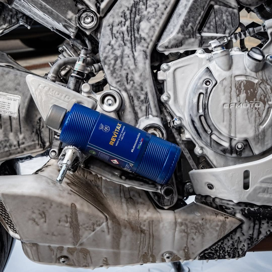 Bottle of Labocosmetica Revitax on Motorbike with shampoo foam and suds.