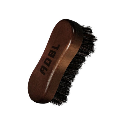 Brown leather brush with black bristles and 'ADBL' branding on a white background.