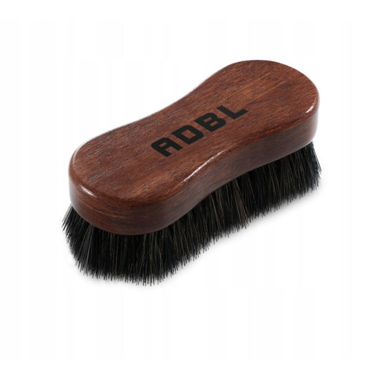 Brown leather brush with black bristles and 'ADBL' branding on a white background.