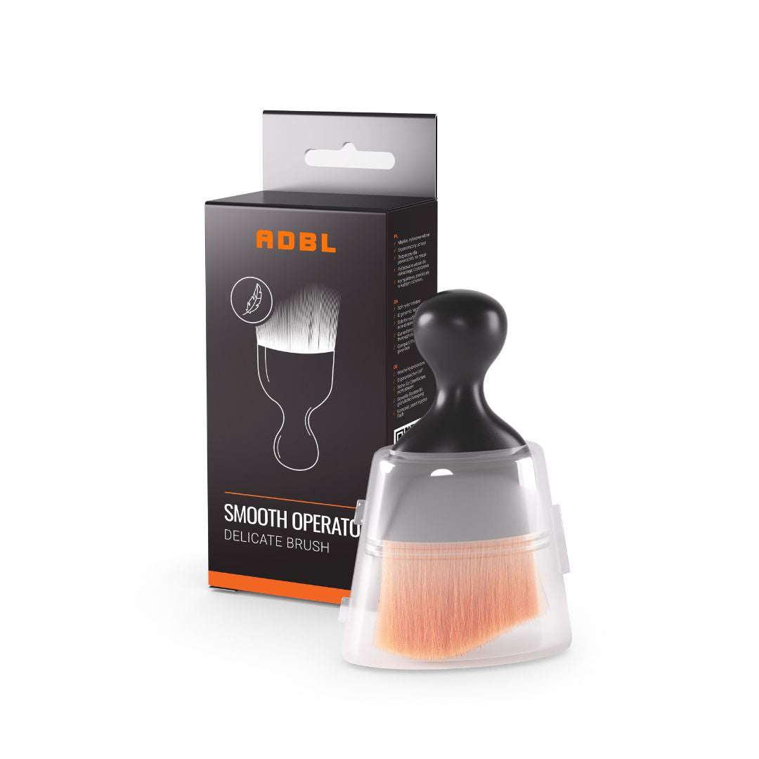 ADBL Smooth Operator Ultra Soft Interior Brush Delicate brush with clear handle and black bristle head next to ADBL branded packaging on a white background