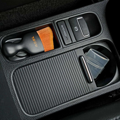 ADBL Smooth Operator Ultra Soft Interior Brush Car console with cup holder, gear shift, and storage compartments.