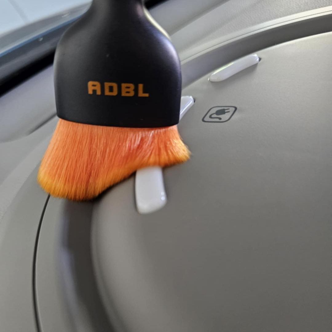 ADBL Smooth Operator Ultra Soft Interior Brush Car cleaning brush with orange bristles and black handle on a car door
