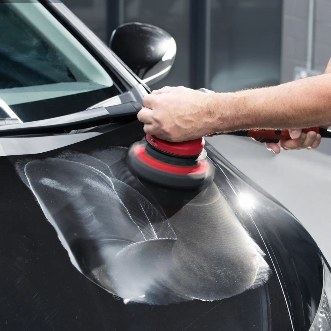Person using a Flex car polishing machine on a black car