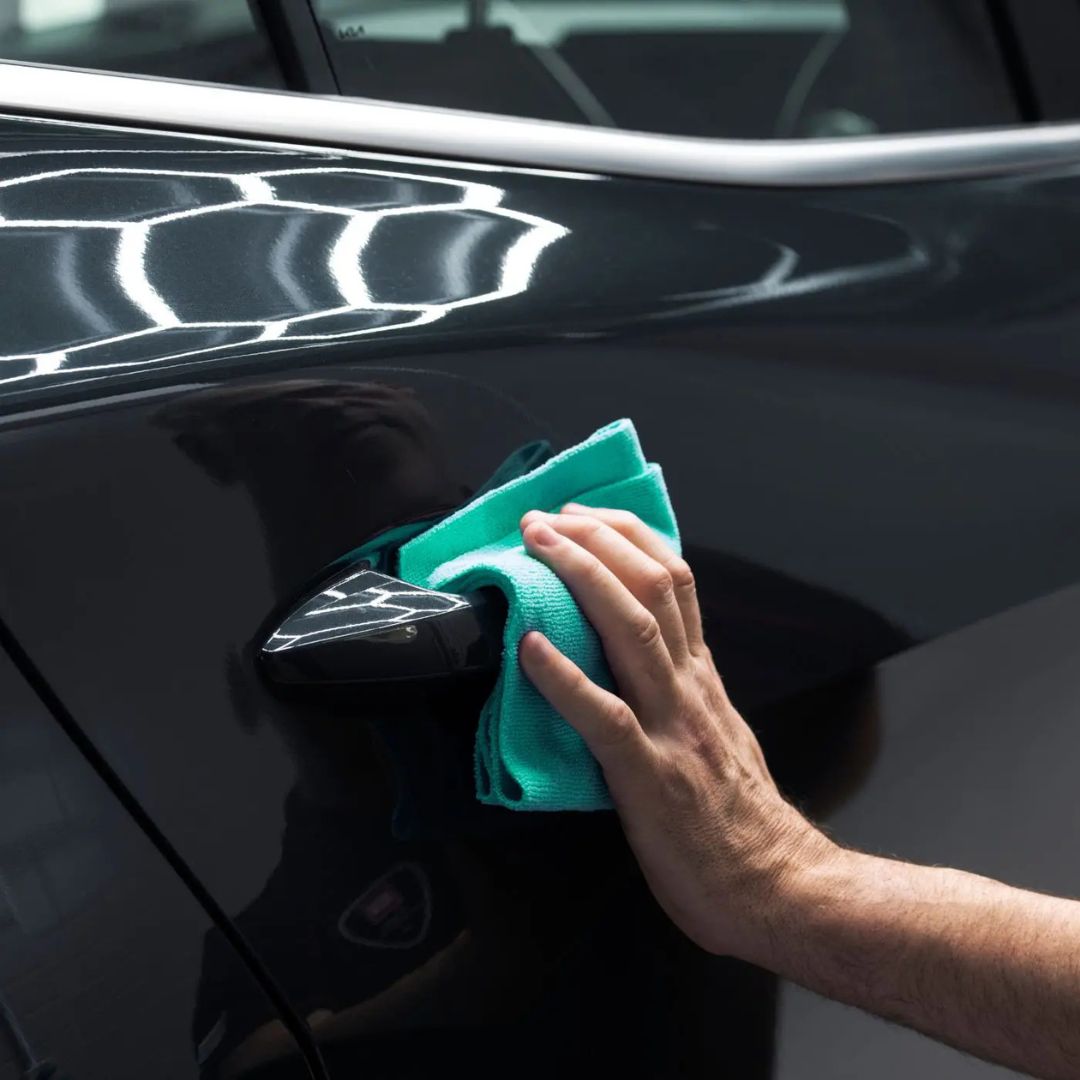 Person cleaning a car door with a green Autoglym All Purpose Cloth 360gsm
