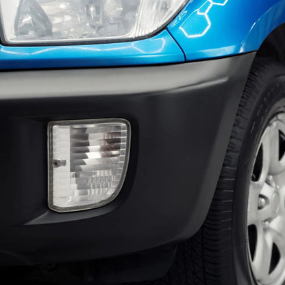 Close-up of a car's headlight and front bumper on a blue vehicle.