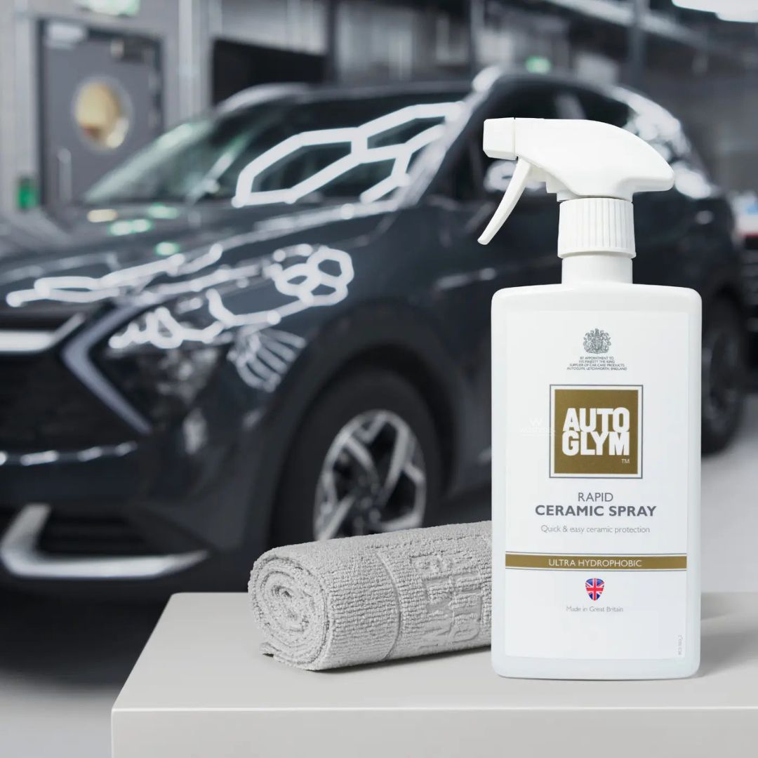 Autoglym ceramic spray bottle with a 2 Autoglym finishing cloths on a car detailing workbench.