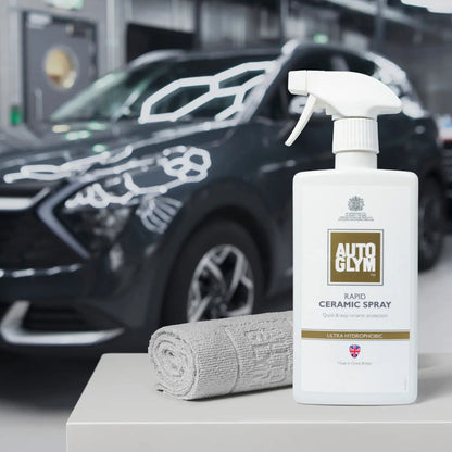 Autoglym ceramic spray bottle with a 2 Autoglym finishing cloths on a car detailing workbench.
