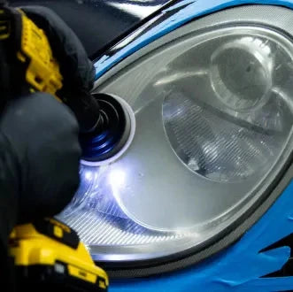 Person using a tool to work on a car headlight.
