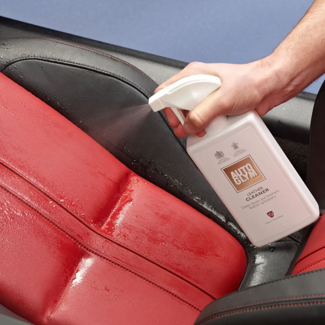 Person cleaning a car seat with AUTOGLYM Leather Cleaner