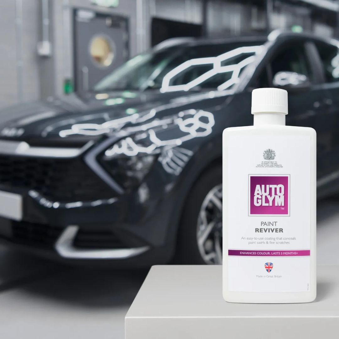 Autoglym Paint Reviver bottle in front of a car in a garage setting