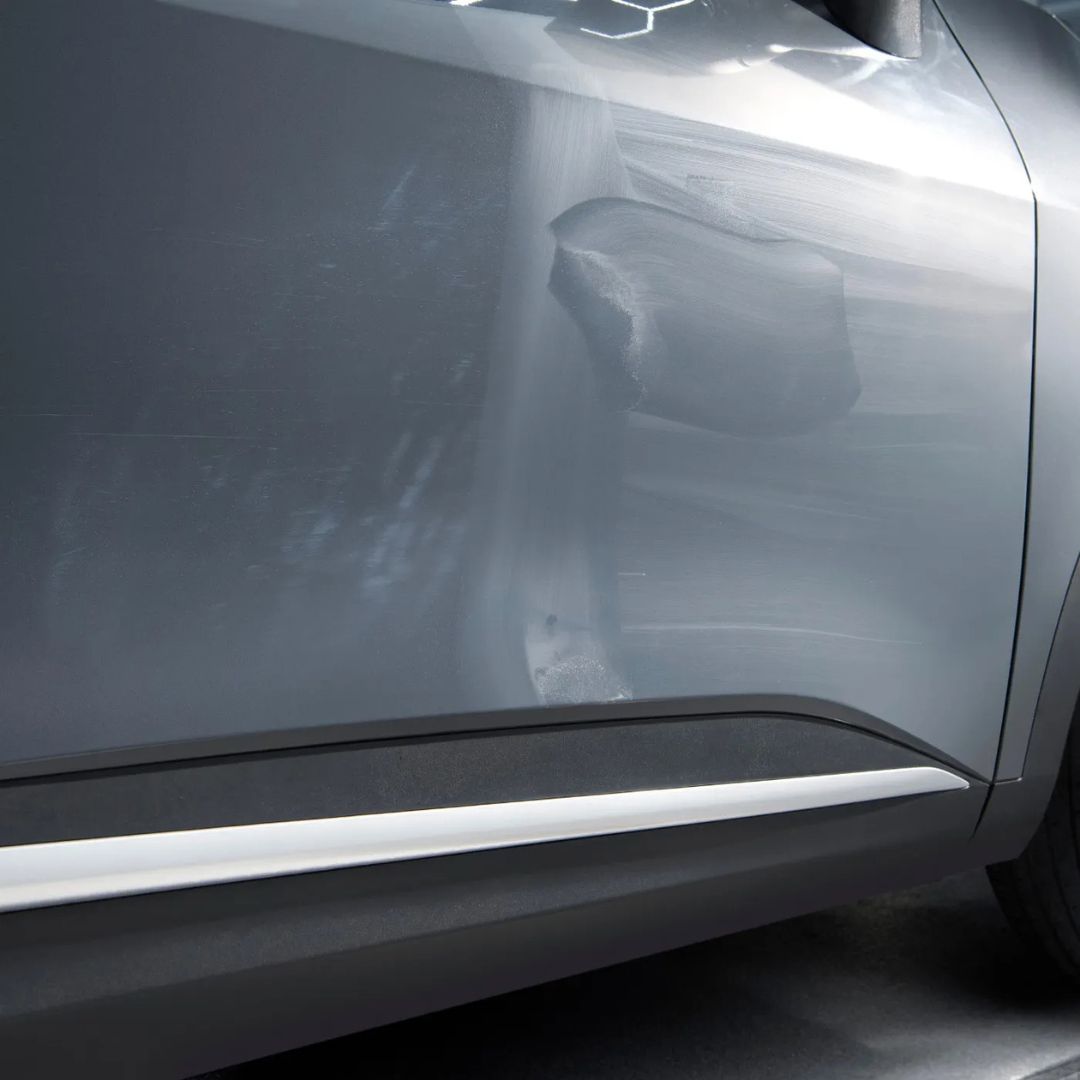 Close-up of a car's side panel with hazing Autoglym Paint Reviver.