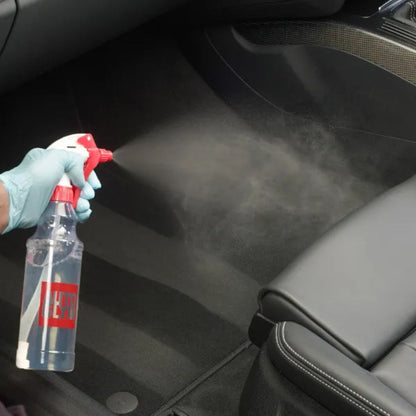 Person cleaning car interior with a spray bottle