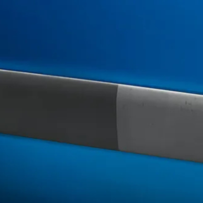 Close-up of a knife blade with a black and silver handle on a blue background