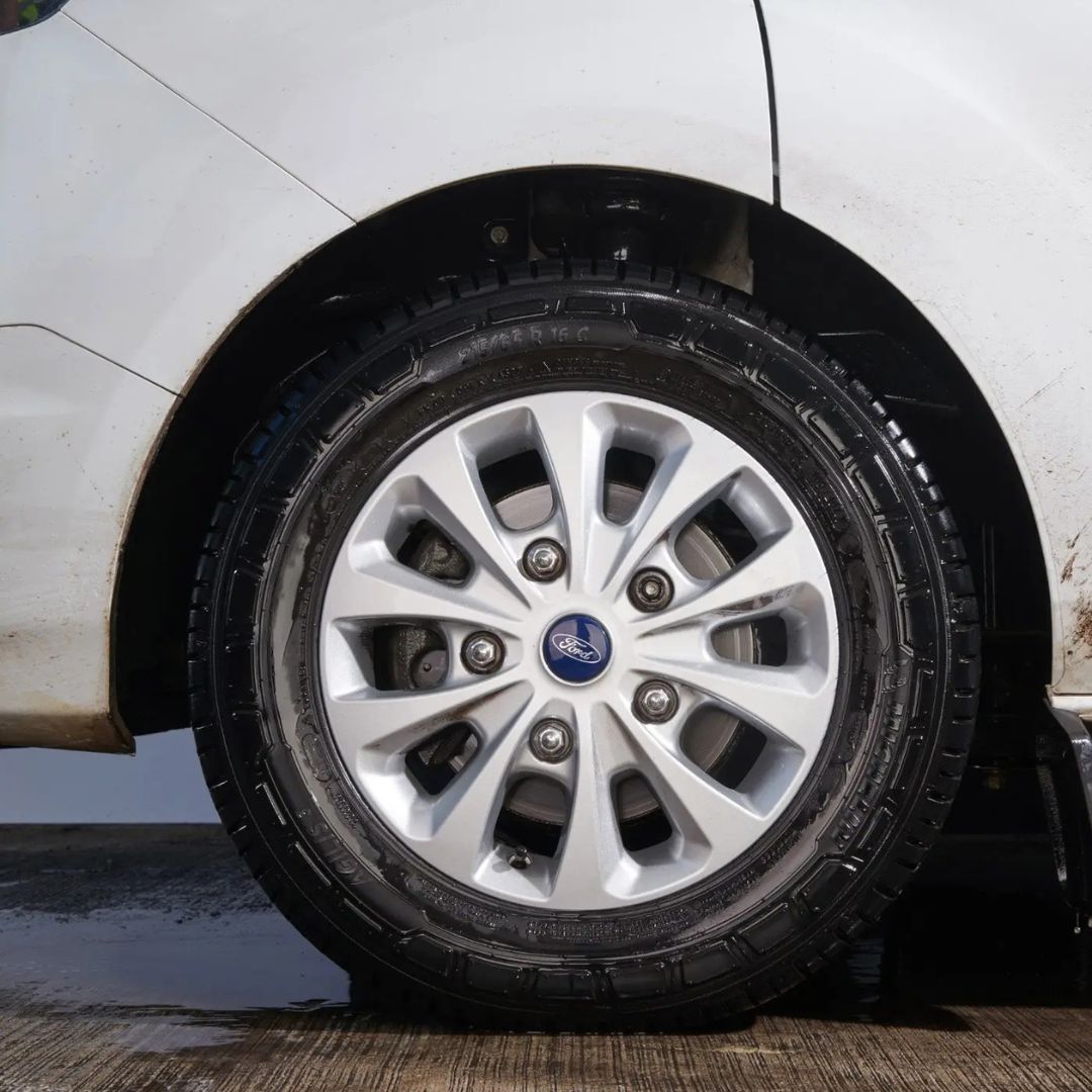Car tire with silver rim on a white car washed with Autoglym Heavy Duty Wheel Cleaner 