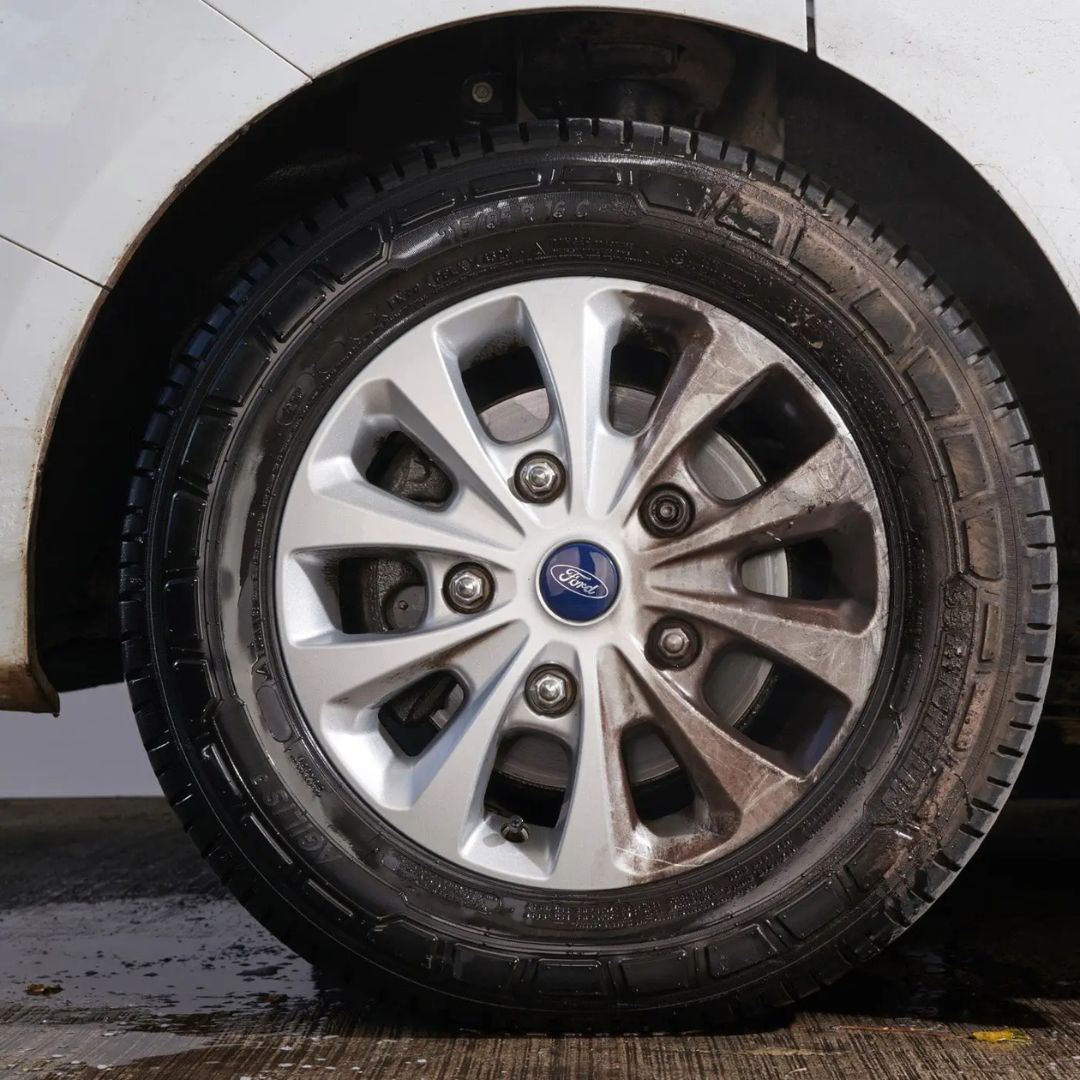 Car tire with visible Ford logo on a white car background