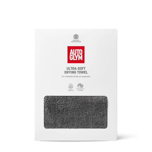 A white retail box for an Autoglym ultra-soft drying towel, featuring a red brand logo and a rectangular window showing a dark gray textured towel inside, on a clean white background.