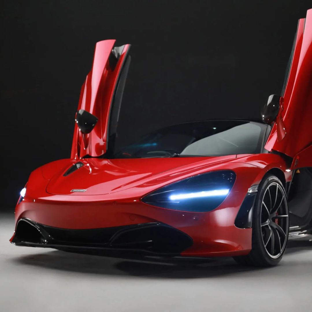 Red sports car with open doors on a dark background