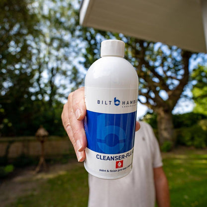 Person holding a bottle of Bilt Hamber Cleanser-Fluid with a blurred outdoor background