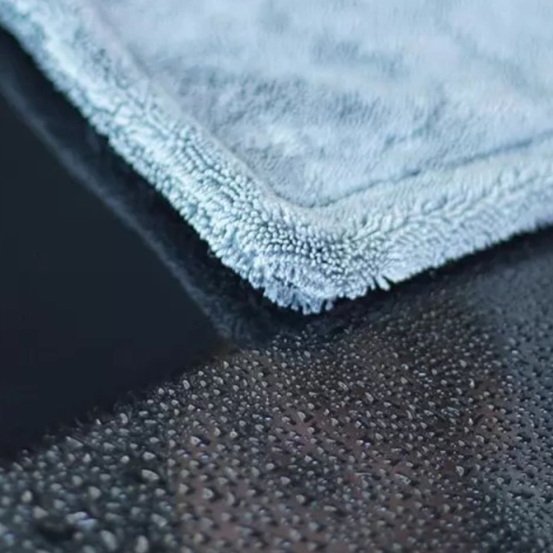Close-up of a textured grey drying towel corner on a dark surface