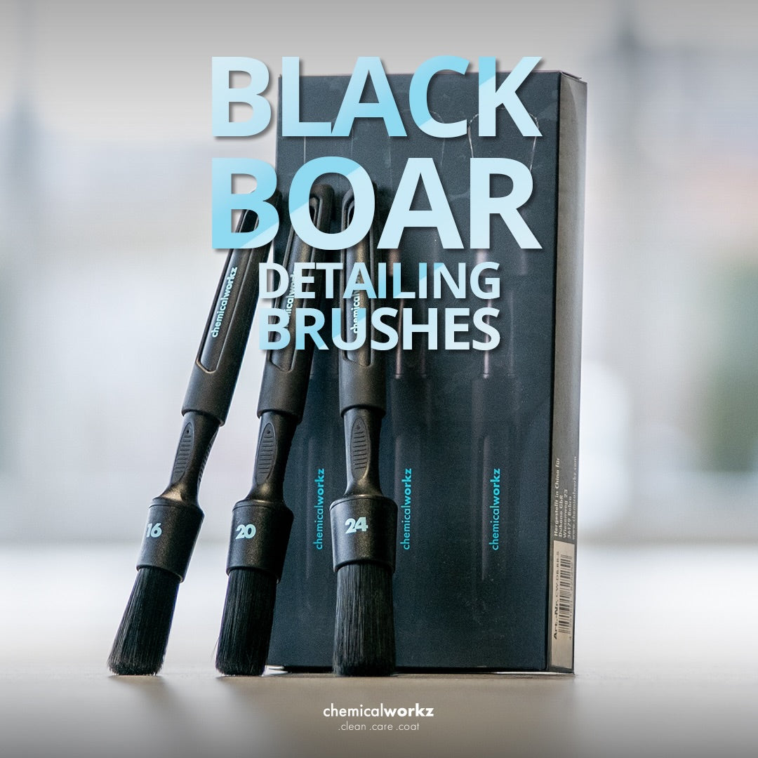 Black boar detailing brushes with packaging on a blurred background