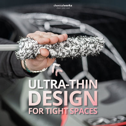 Person holding a car cleaning brush with text about ultra-thin design for tight spaces.