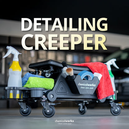 Car detailing creeper stool with cleaning supplies and 'chemicalworkz' branding in a garage setting.