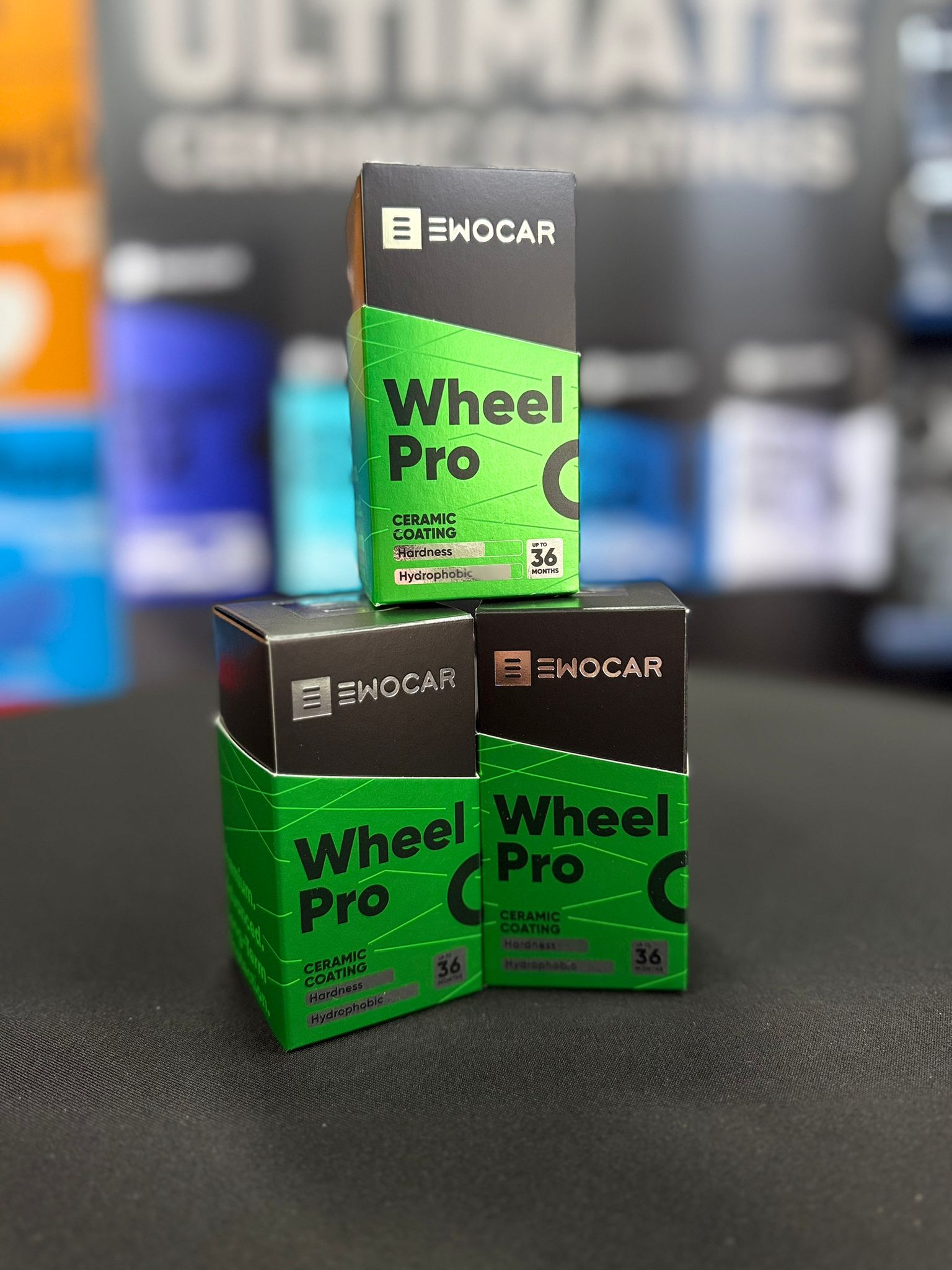 Three boxes of Ewocar Wheel Pro on a dark surface with blurred colorful background