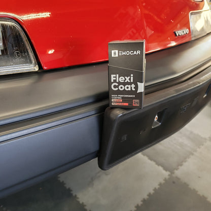 A box of EWOCAR Flexi  Coat on a Volvo 480  heavy-duty bumper protector is shown mounted onto the black plastic bumper of a red Volvo truck.