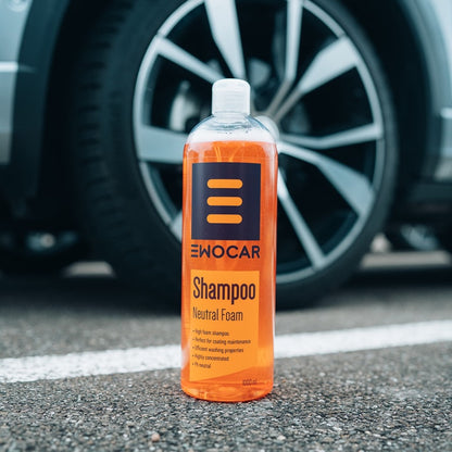 Bottle of Ewocar shampoo on a car's black rubber tire