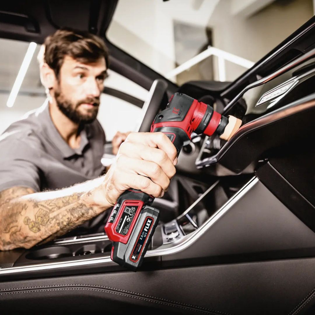 Man using a red and black Flex PXE 80 inside a vehicle