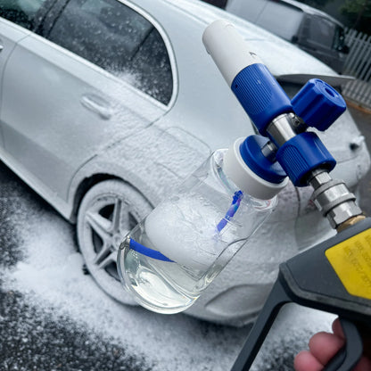 Car wash gun with soap bottle in front of a car