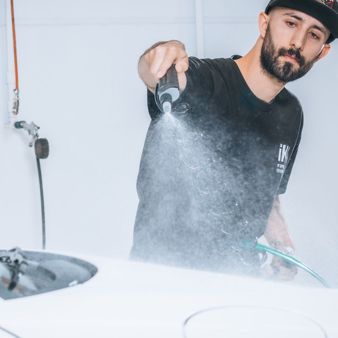 Person using a IK Window Tinting and PPF Sprayer Stainless Steel 13L on white car