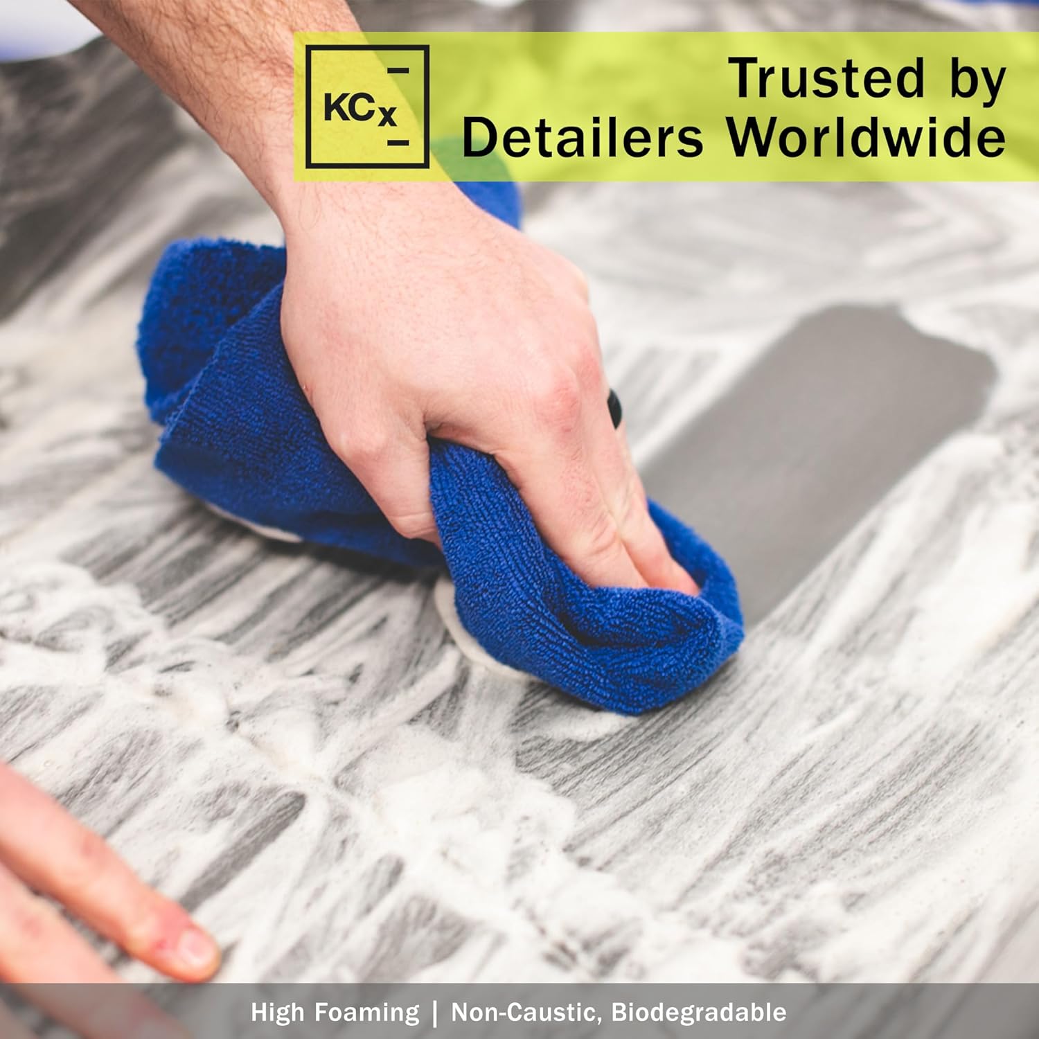 Hand using a blue towel to clean a surface with KCx logo and text about trustworthiness.