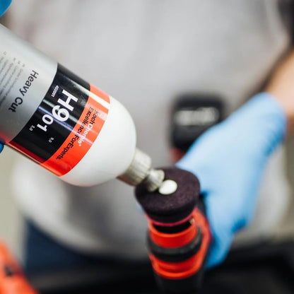 Person applying Koch Chemie “H9.02. Heavy Cut” polishing compound to a small wine coloured polishing pad.