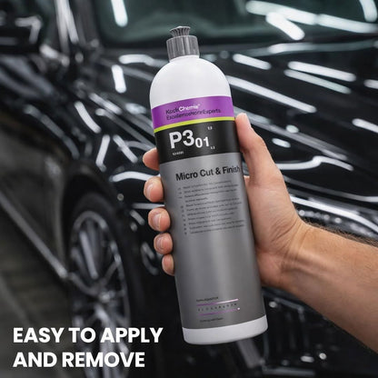 Hand holding a bottle of Koch Chemie Micro Cut & Finish P3.01 polishing compound product with a car in the background.