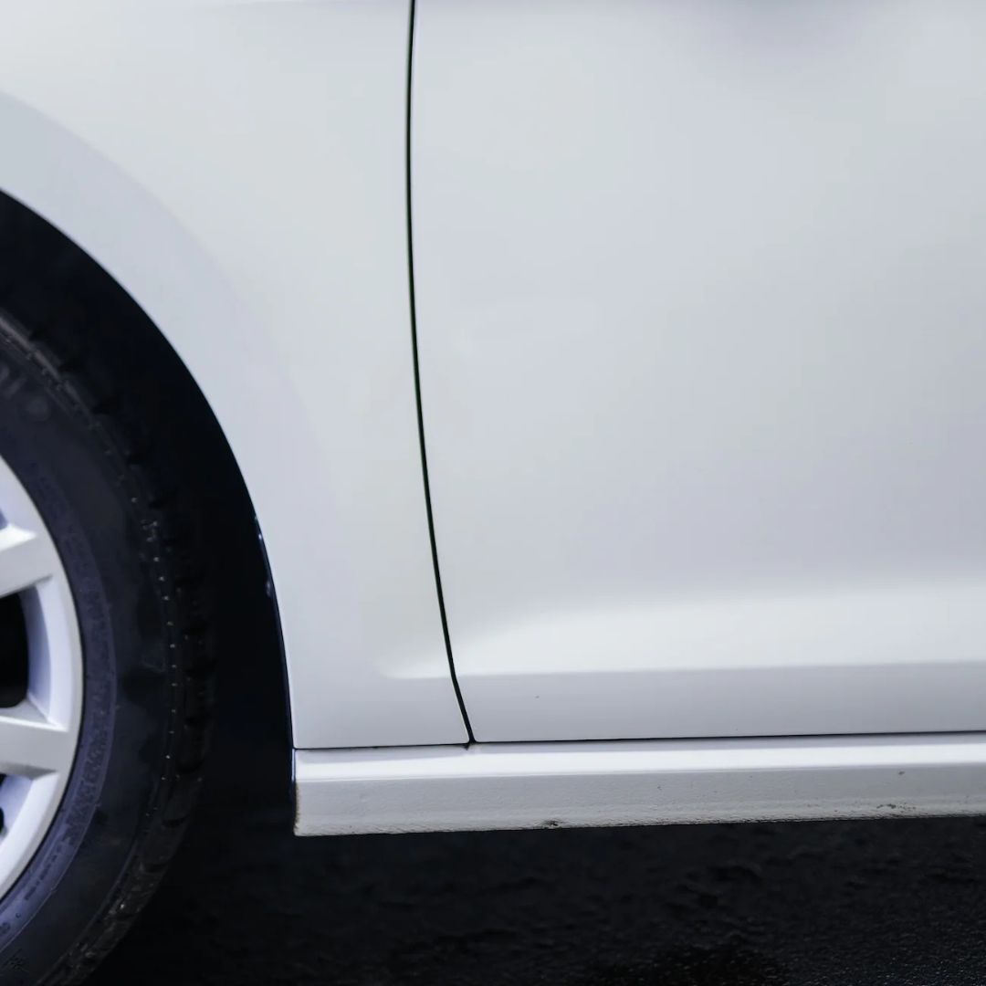 Close-up of a white car's side after removing tar spots with Koch Chemie TEA