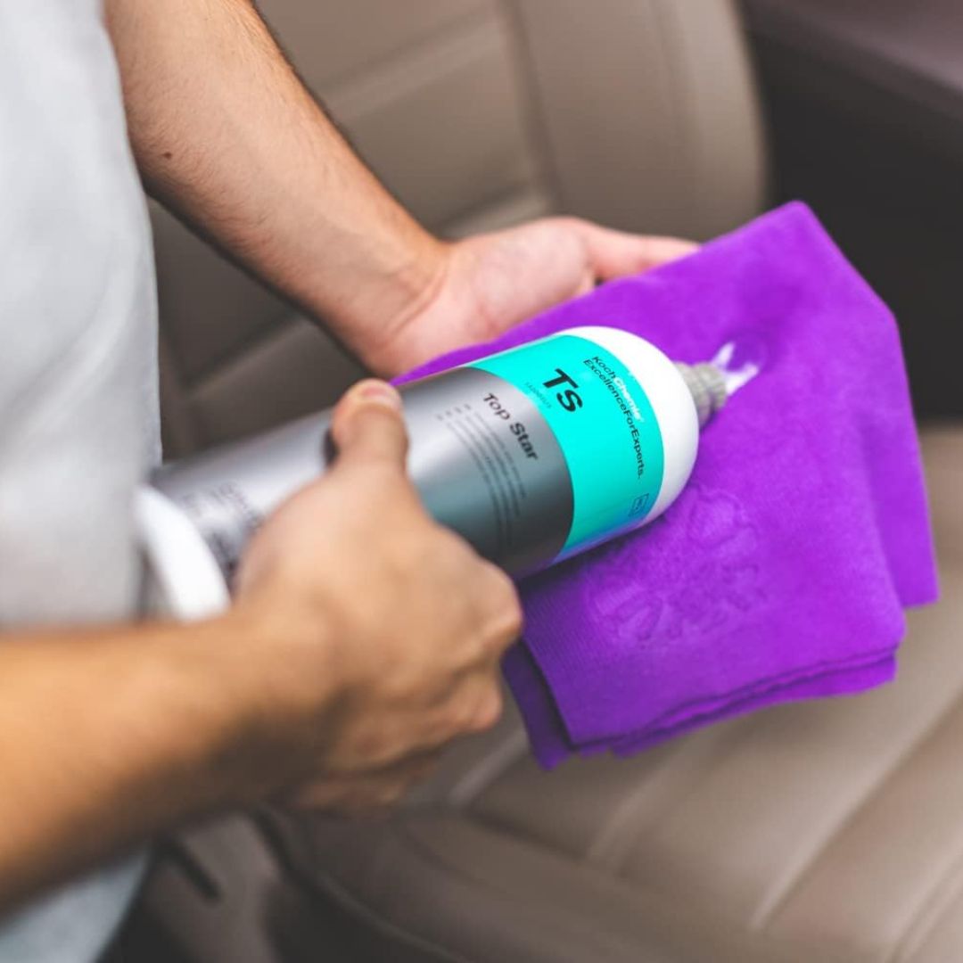 Koch Chemie TS Top Star Interior Plastic Cleaner and Dressing Person cleaning a car seat with a purple towel and TS brand product.